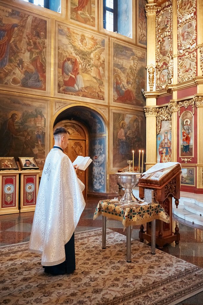 Священник читає молитву біля купелі у Михайлівському соборі