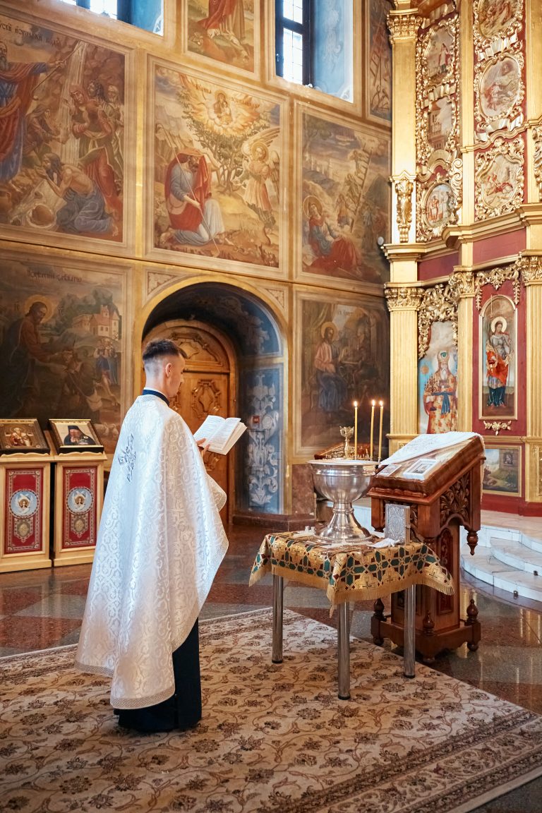 Священник читає молитву біля купелі у Михайлівському соборі