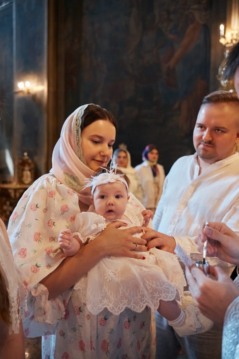 Жінка тримає Софію біля купелі під час підготовки до хрещення