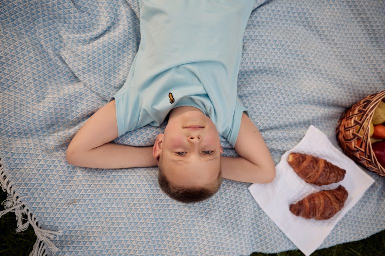 Чоловік і жінка цілуються на дерев'яній доріжці біля водойми