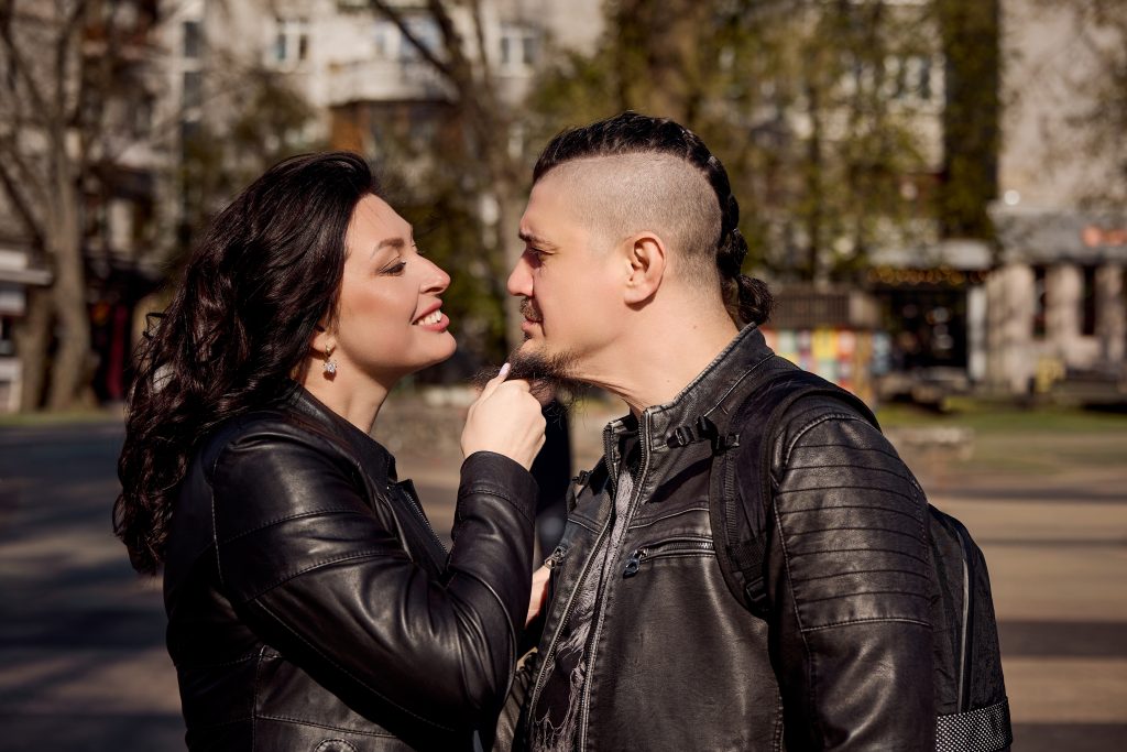 Пара у шкіряних куртках ніжно дивиться одне на одного на міській вулиці