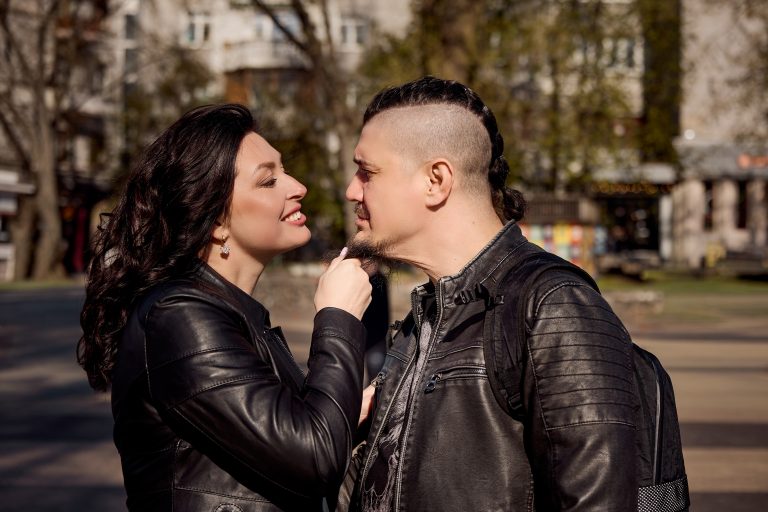 Пара у шкіряних куртках ніжно дивиться одне на одного на міській вулиці