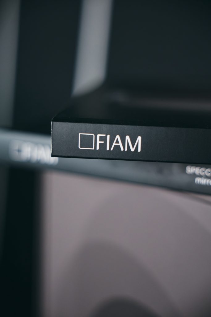 Логотип FIAM на чорному каталозі в темному інтер'єрі