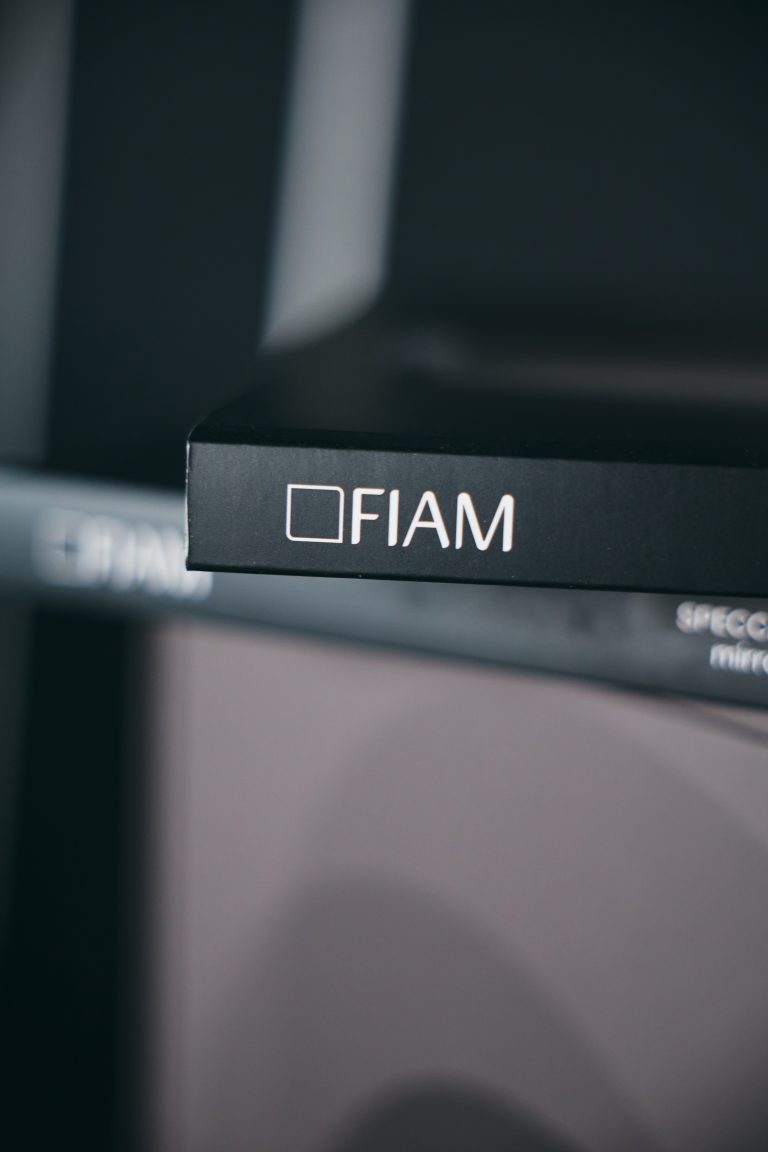 Логотип FIAM на чорному каталозі в темному інтер'єрі