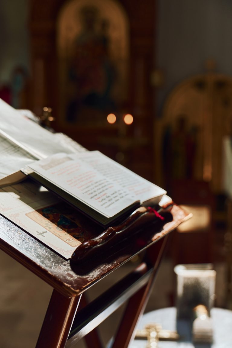 Відкрита богослужбова книга на дерев'яному аналої в православному храмі