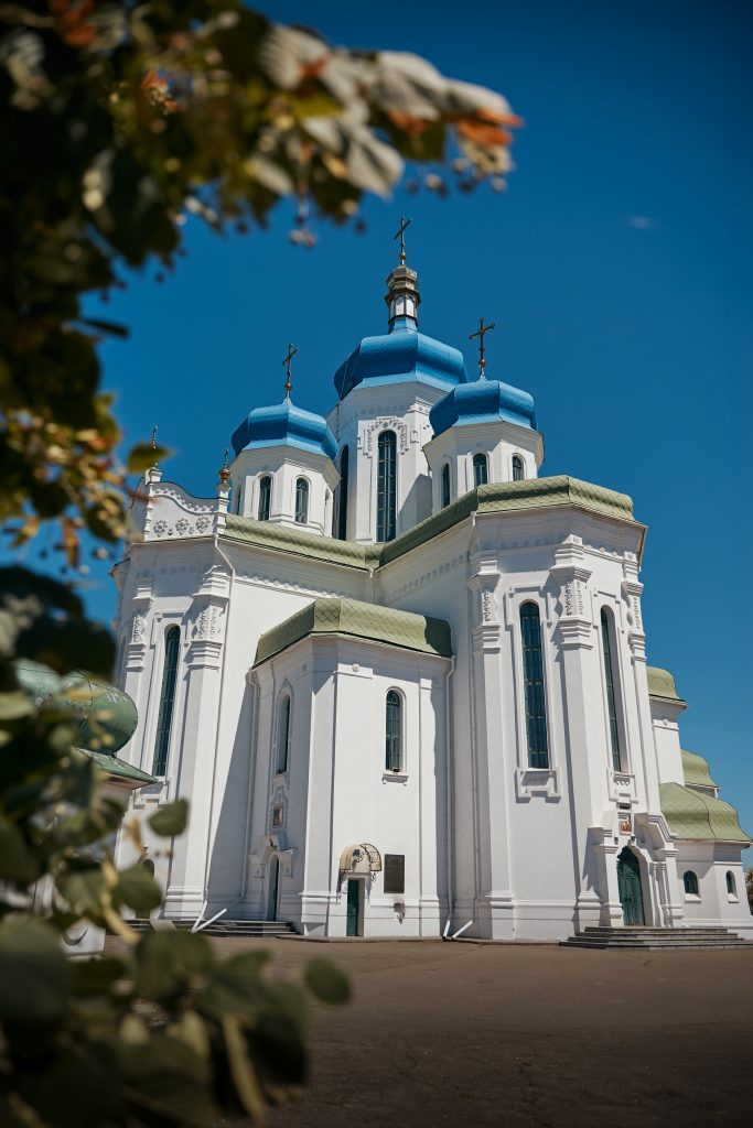 Фасад Свято-Троїцького храму на Троєщині з блакитними куполами у сонячний день