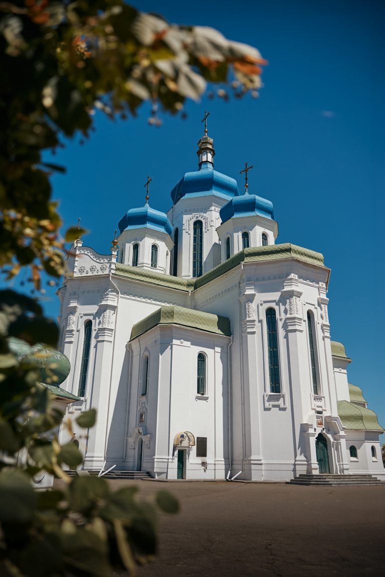 Фасад Свято-Троїцького храму на Троєщині з блакитними куполами у сонячний день