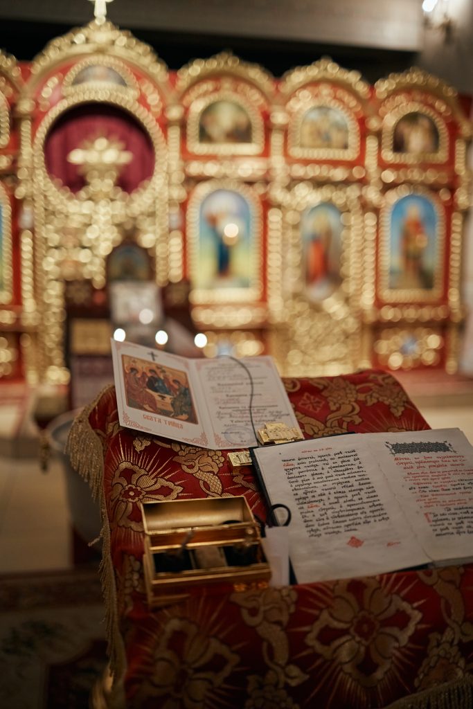 Церковні книги та свідоцтво про хрещення на червоному аналойному покритті перед іконостасом
