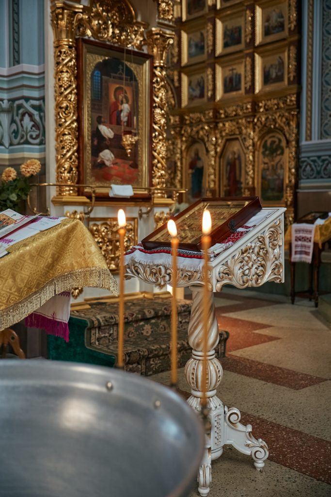 Інтер'єр православного храму з іконами, запаленими свічками та купіллю на передньому плані