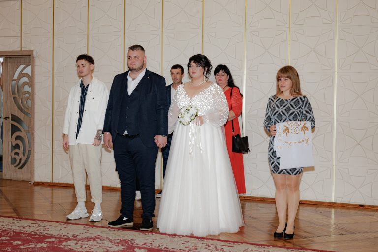 Наталя і Влад стоять разом у залі Деснянського РАЦСу під час церемонії одруження