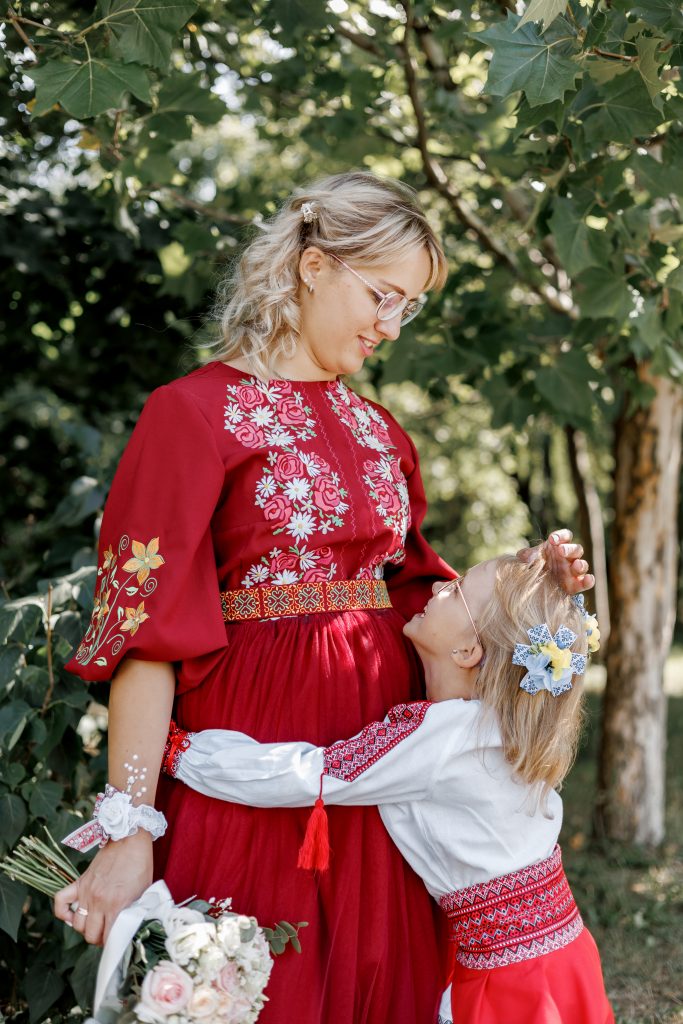 Веронічка обіймає Марину у парку, обидві у вишитих святкових образах