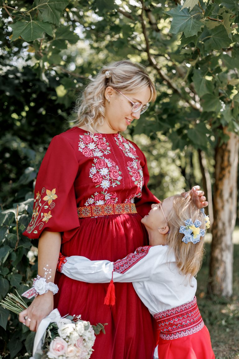 Веронічка обіймає Марину у парку, обидві у вишитих святкових образах