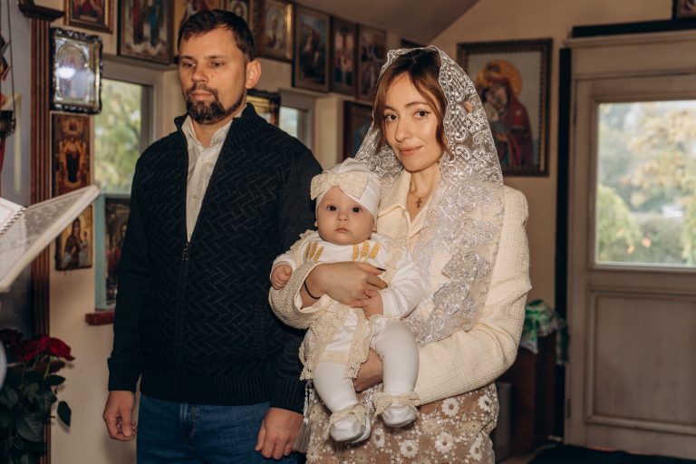 Чоловік і жінка з Уляною на руках стоять у храмі перед початком хрещення