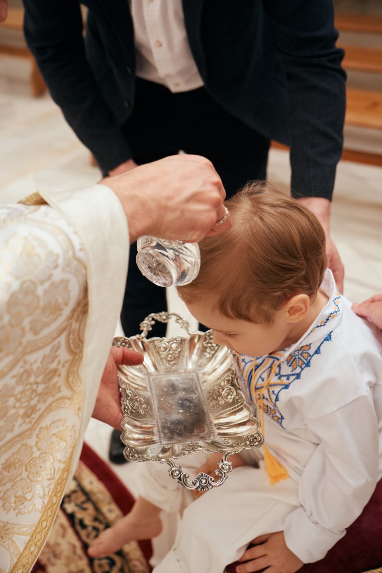 Священник ллє воду на голову Ярослава над срібною чашею під час хрещення